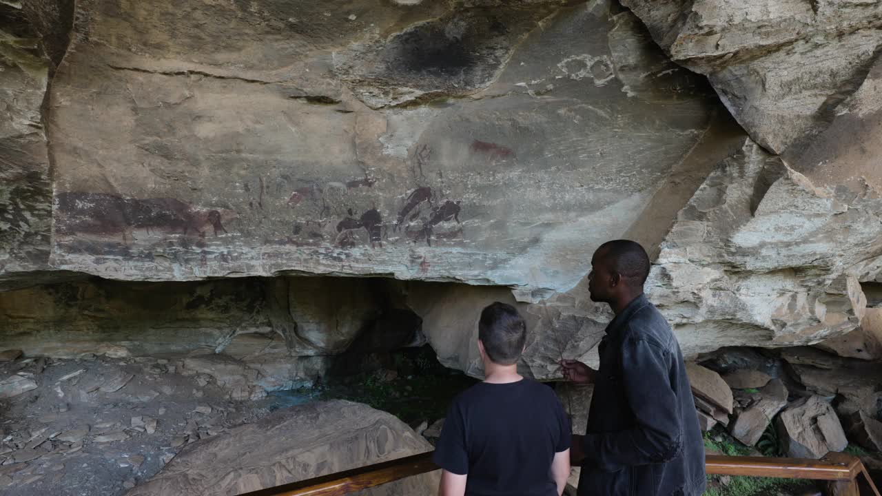 南非夸祖鲁-纳塔尔省德拉肯斯堡巨人城堡内，导游带领游客参观保存完好的圣布希曼绘画视频素材