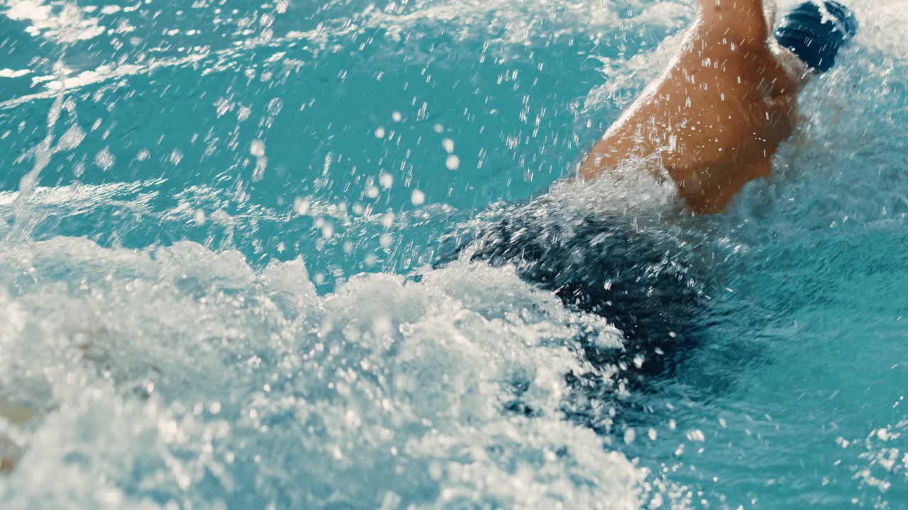 男子游泳运动员在奥林匹克游泳池中游泳。职业运动员在锦标赛上表演，使用自由泳，自由泳。赢的决心。高角度电影后跟踪慢动作视频素材