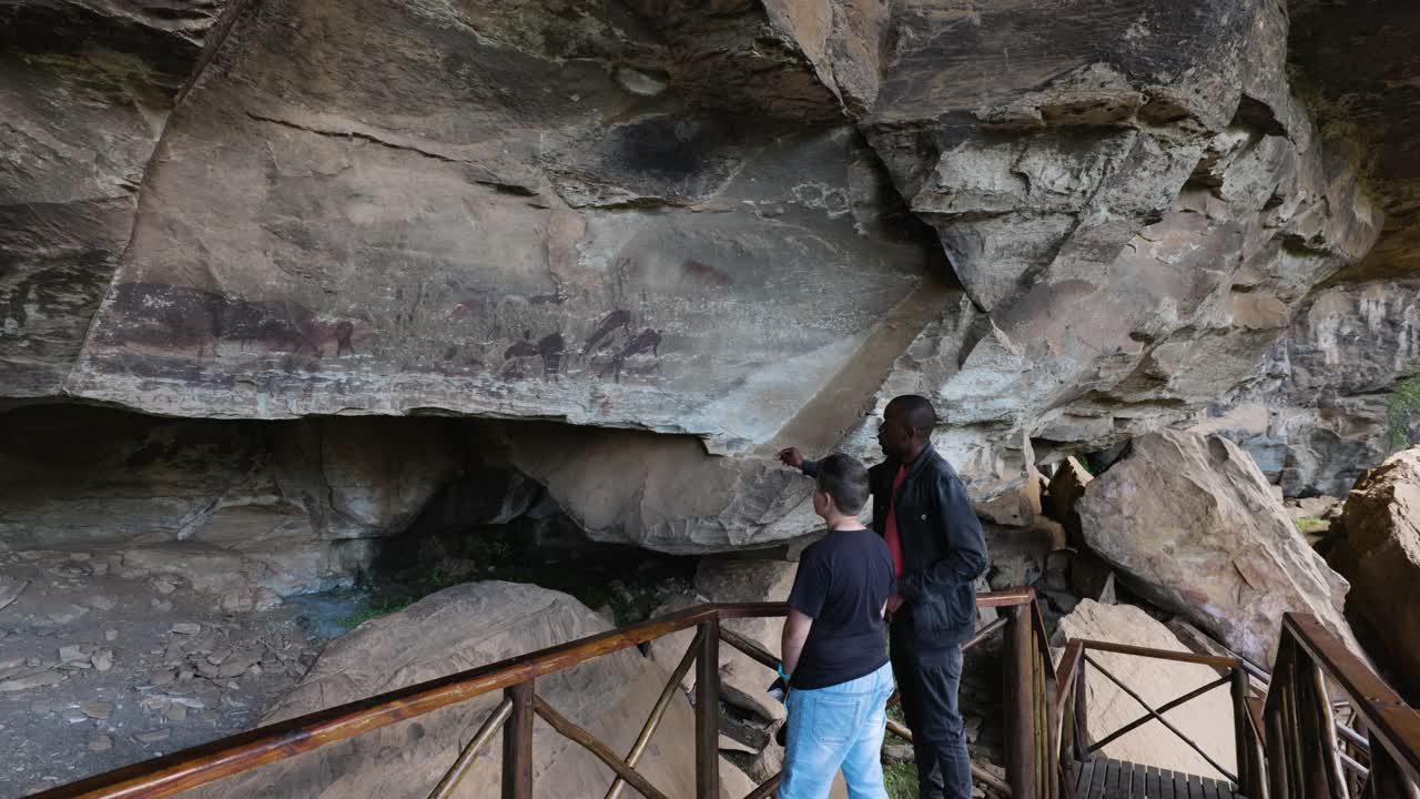 南非夸祖鲁-纳塔尔省德拉肯斯堡巨人城堡内，导游带领游客参观保存完好的圣布希曼绘画视频素材