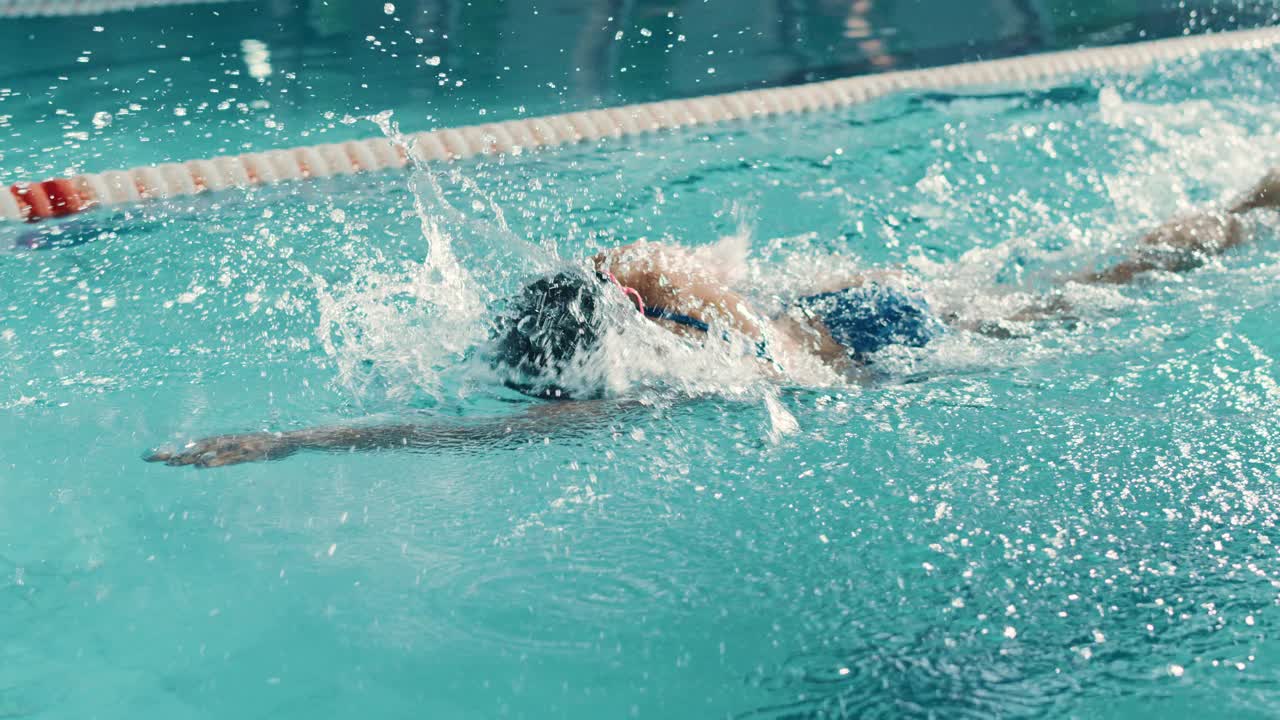 美丽的女子游泳运动员使用前爬泳，自由泳在游泳池。职业运动员训练以赢得冠军。电影慢动作，时尚的颜色，艺术高角度跟踪镜头视频素材