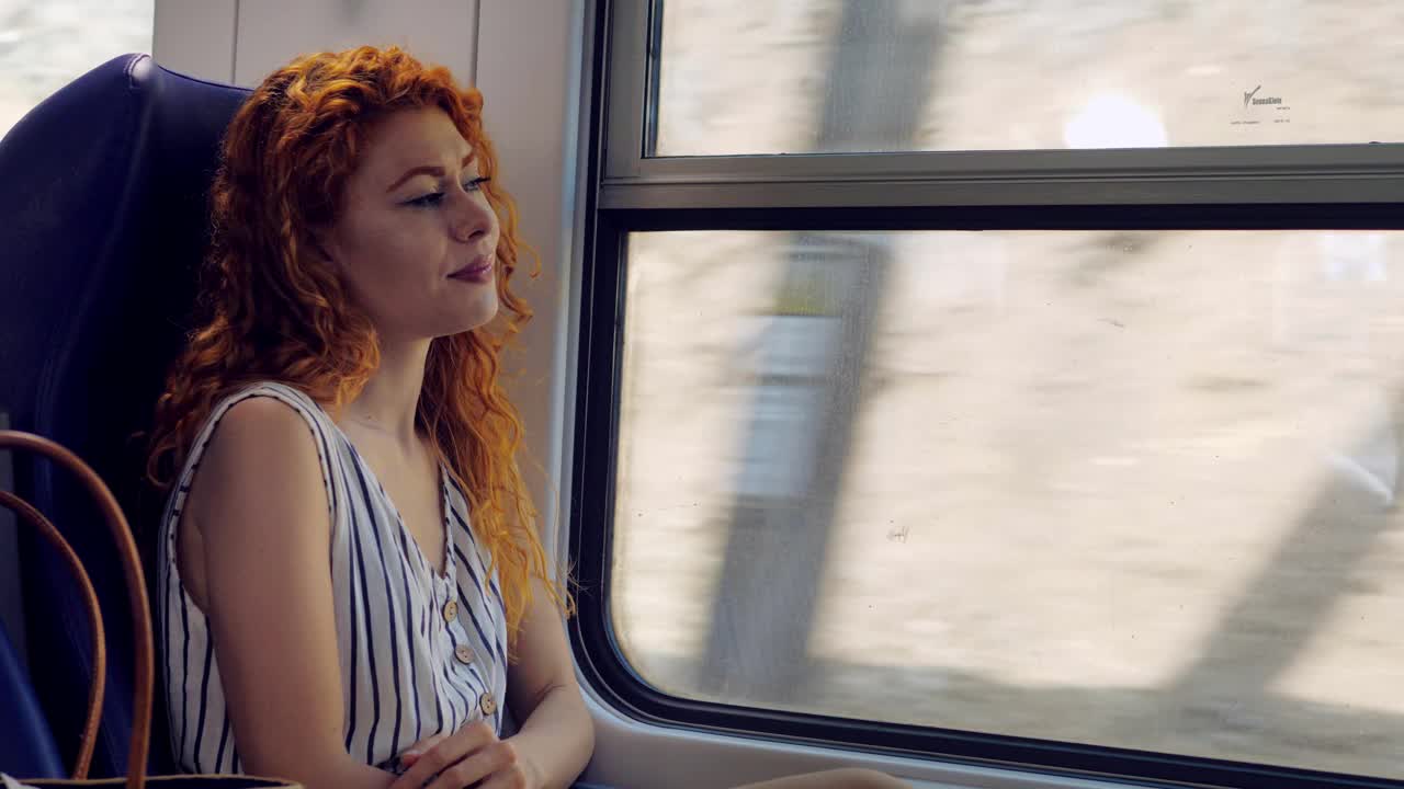 自信，年轻的女人在火车上微笑想着她的假期视频素材