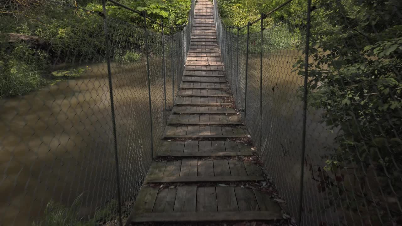 古老的行人悬吊木索桥横跨乡村河上视频下载