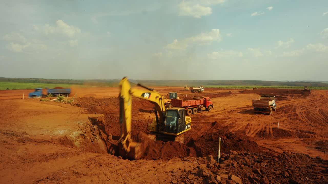 施工现场，挖掘机将土装进自卸车视频下载