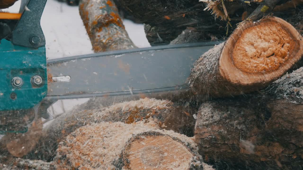 伐木工在冬天用链锯锯木柴视频下载