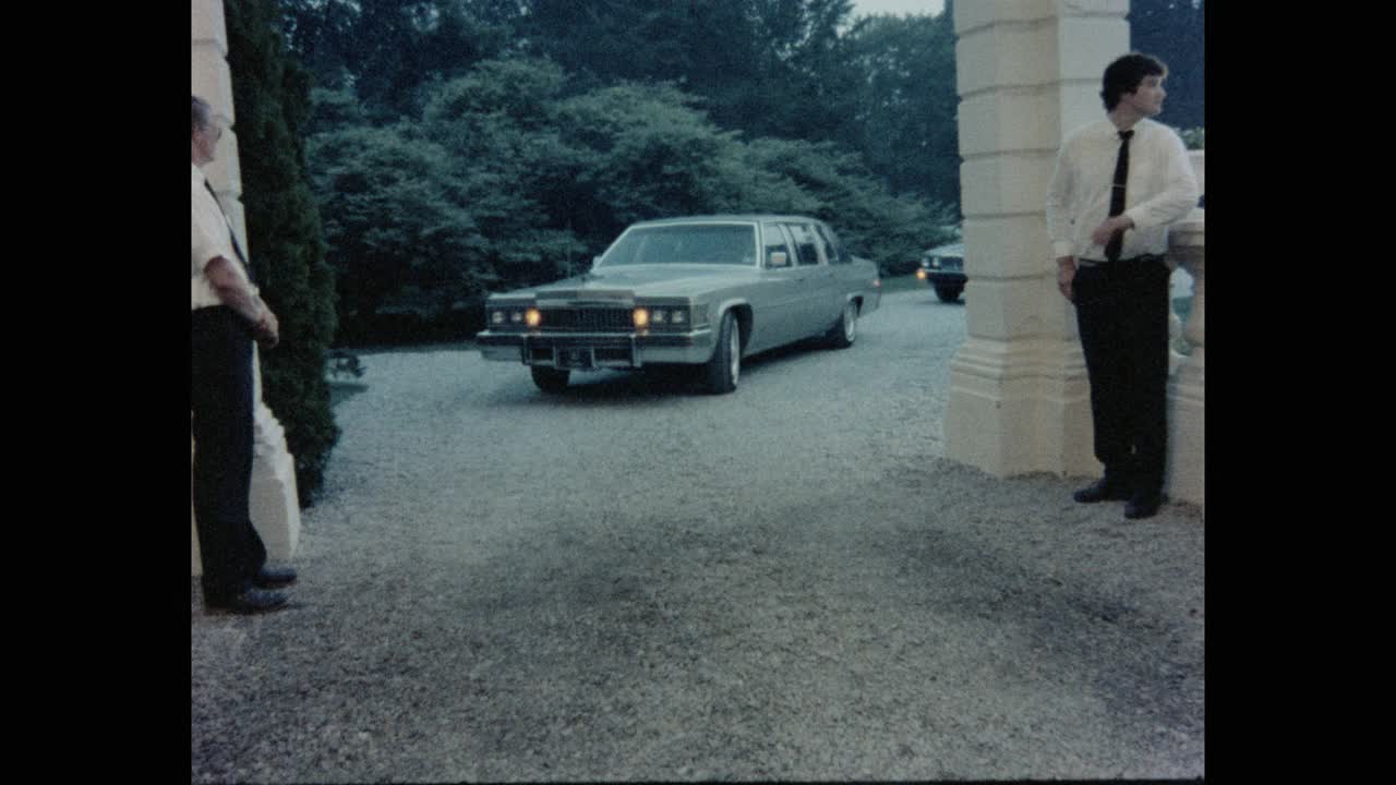 1984年的今天，在美国罗德岛的豪宅入口处，一辆汽车在车道上与仆人一起行驶视频素材