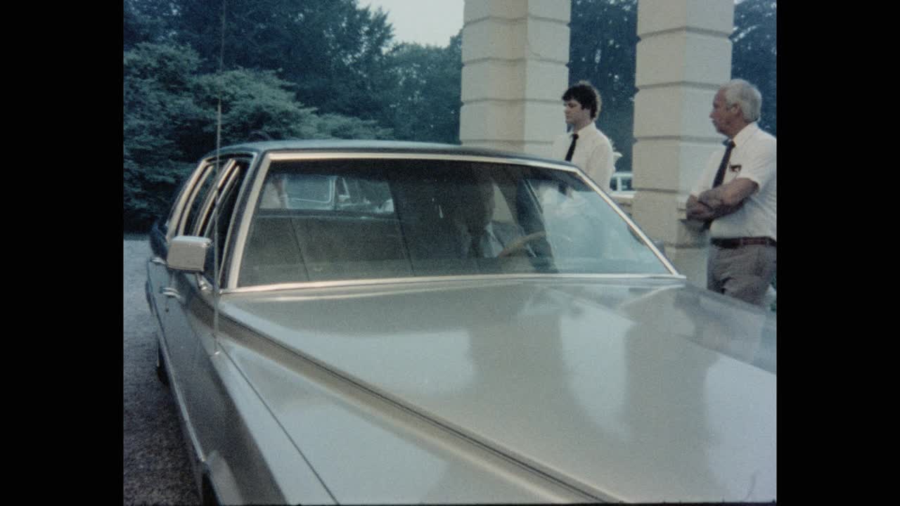 1984年的今天，美国罗德岛州，一对穿着正式的夫妇进入豪宅，男仆站在车道上的汽车旁视频素材