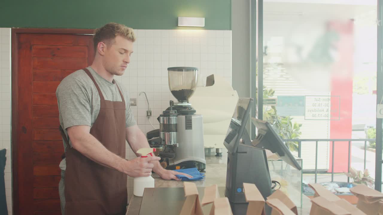 咖啡师员工在开店前使用酒精喷雾设备为顾客服务视频素材