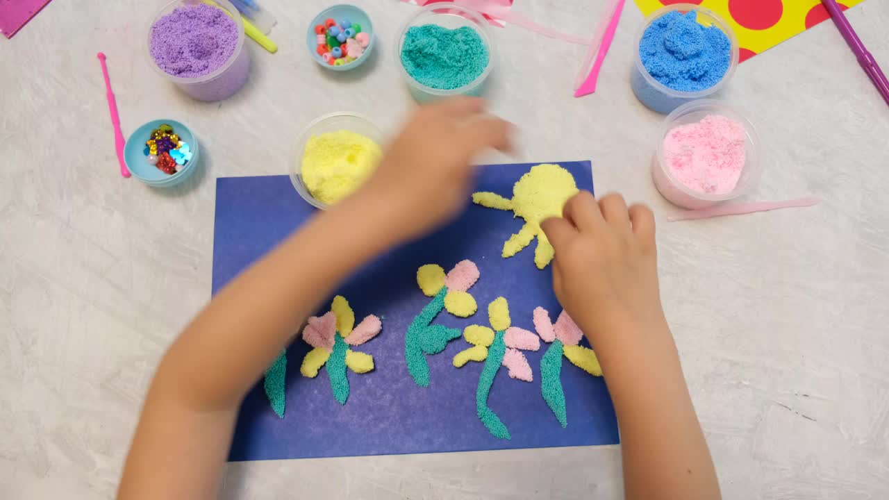 孩子自制贺卡。小女孩用纸和泡沫粘土、橡皮泥制作鲜花，作为母亲节、生日或情人节的礼物。艺术工艺概念。视频下载