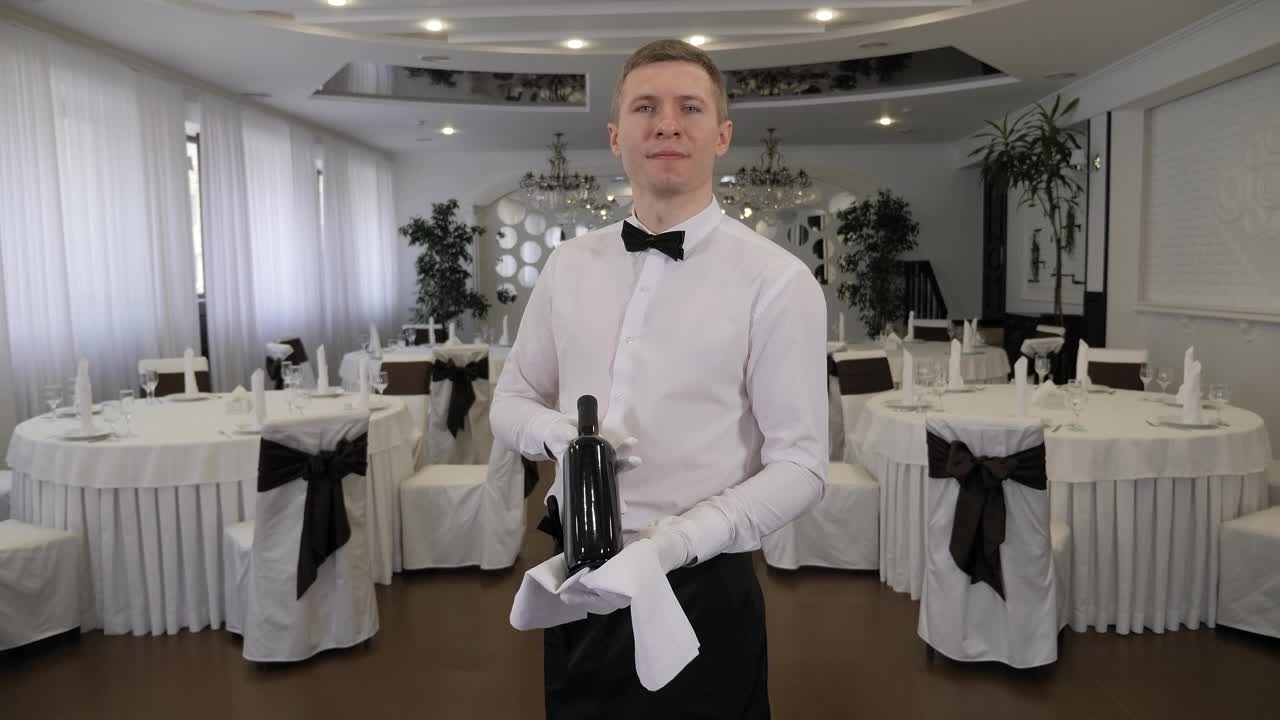 餐厅服务员拿着一瓶酒的肖像。视频下载
