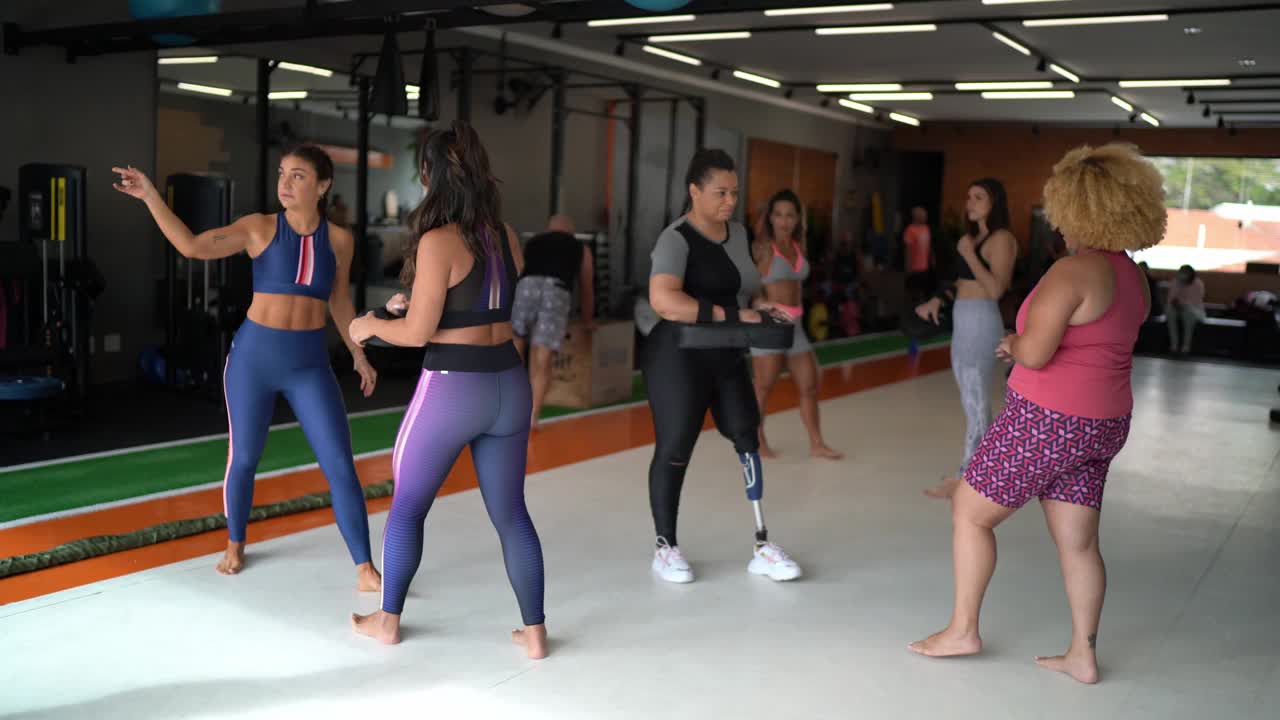 在健身房功能训练的休息时间，一群女人在聊天视频下载