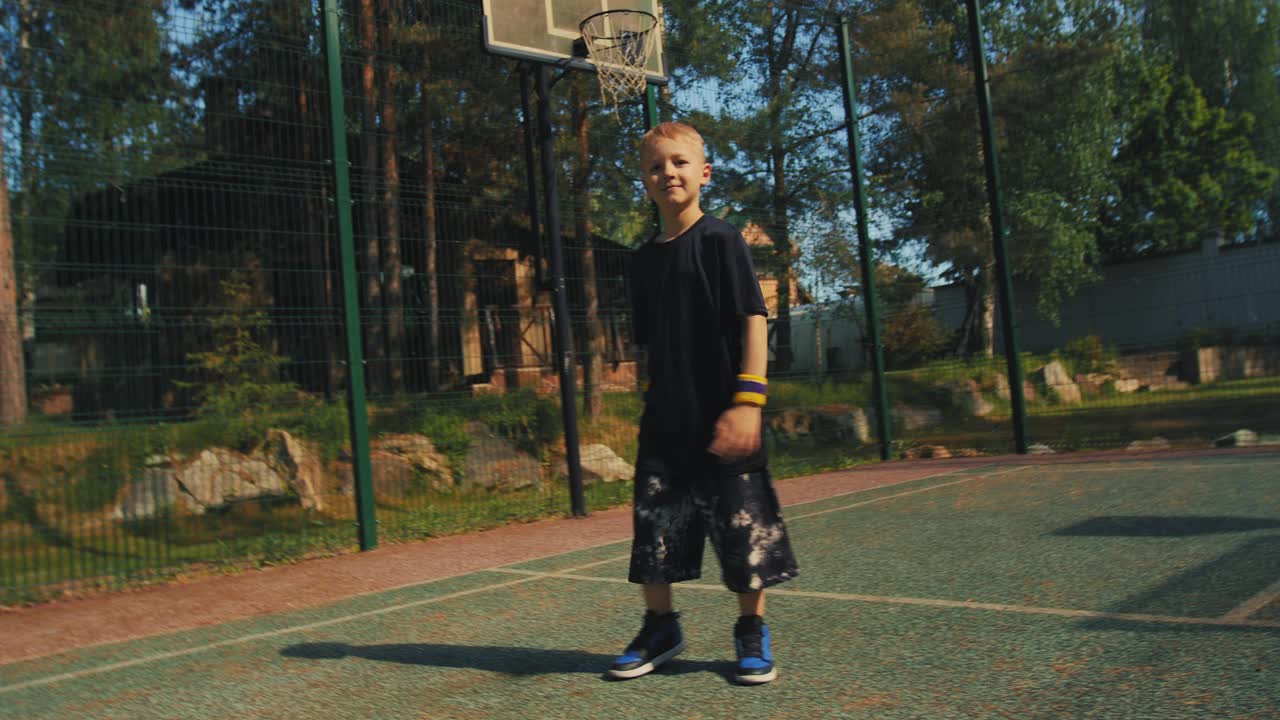 跳舞的男孩在篮球场上表演霹雳舞。酷炫的户外霹雳舞童星视频下载