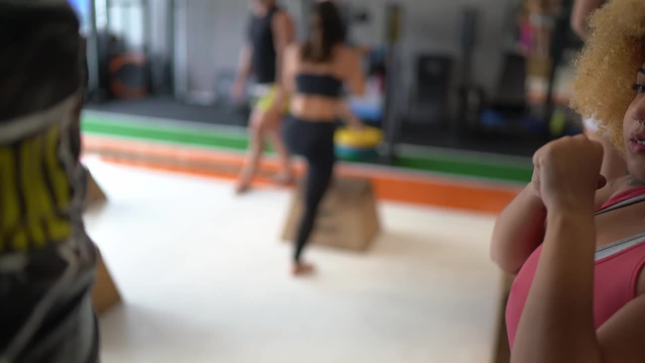 年轻女子在体育馆练习拳击视频下载