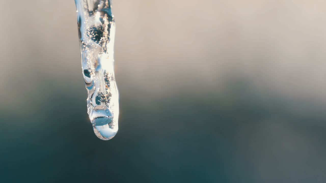 冰柱在春天的阳光下融化。水滴从融化的冰柱上流下，靠近冰柱视频素材