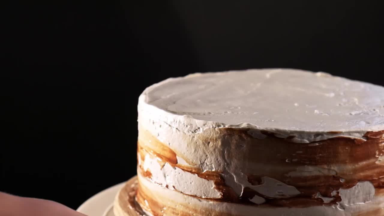 厨师的手在巧克力蛋糕上涂奶油。制作多层巧克力蛋糕视频下载