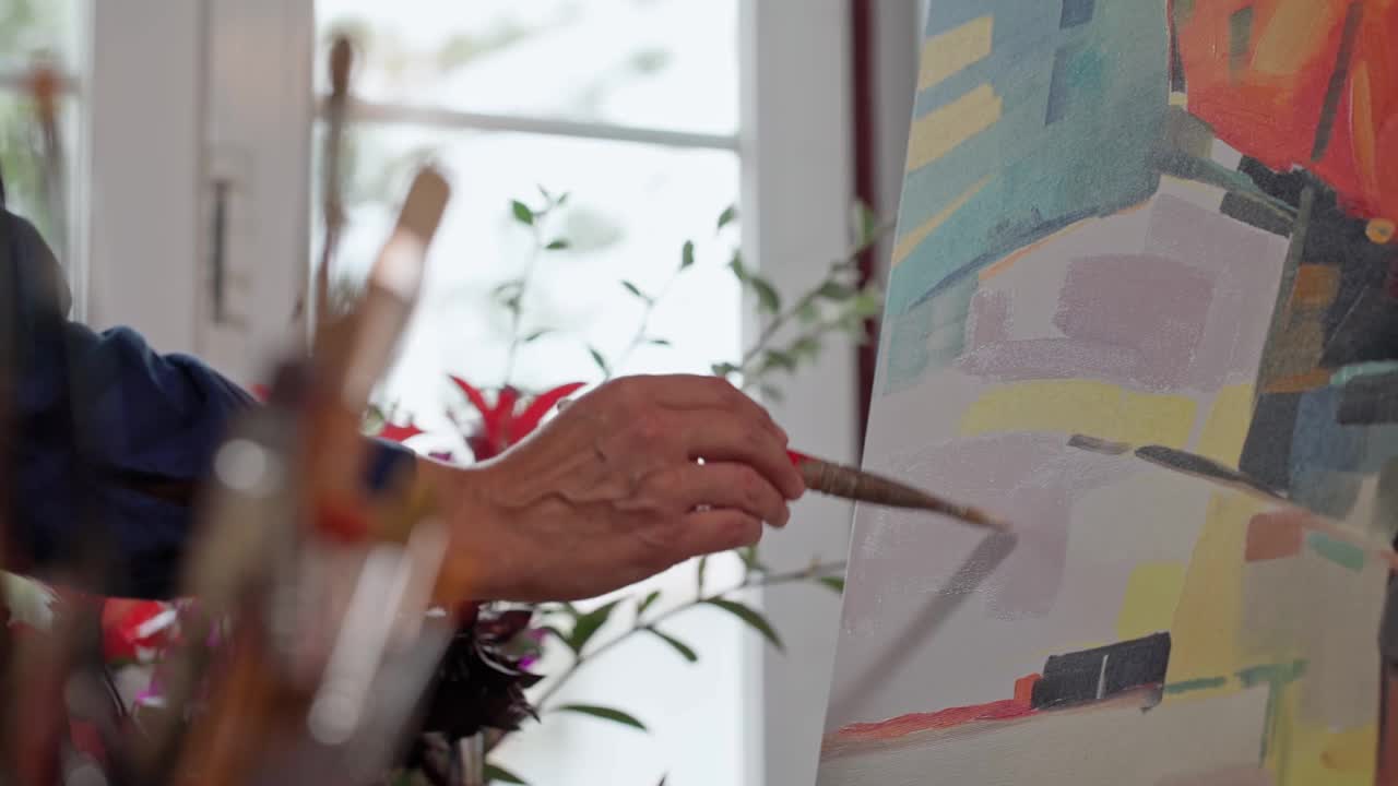 女艺术家用画笔在画布上作画，画特写。抽象绘画。慢动作视频素材