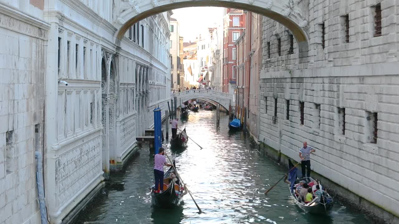 船夫在叹息威尼斯的桥下游泳，意大利。威尼斯叹息桥。浪漫之地叹息桥视频素材