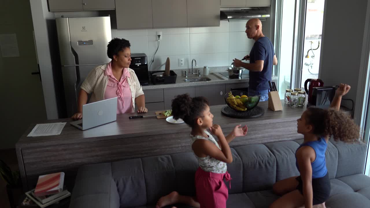 父母做饭/工作和女孩玩拍手游戏回家视频素材