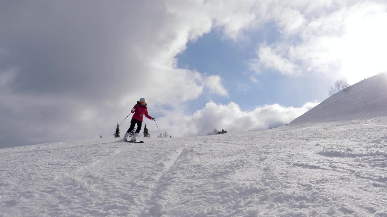 冬季阳光明媚，滑雪者在滑雪场雪山上滑雪视频素材