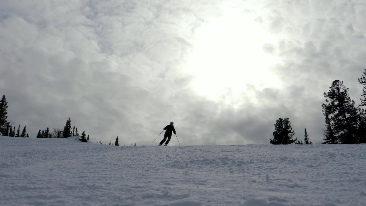 冬季阳光明媚的一天，高山滑雪者在高山滑雪场的斜坡上滑雪视频素材