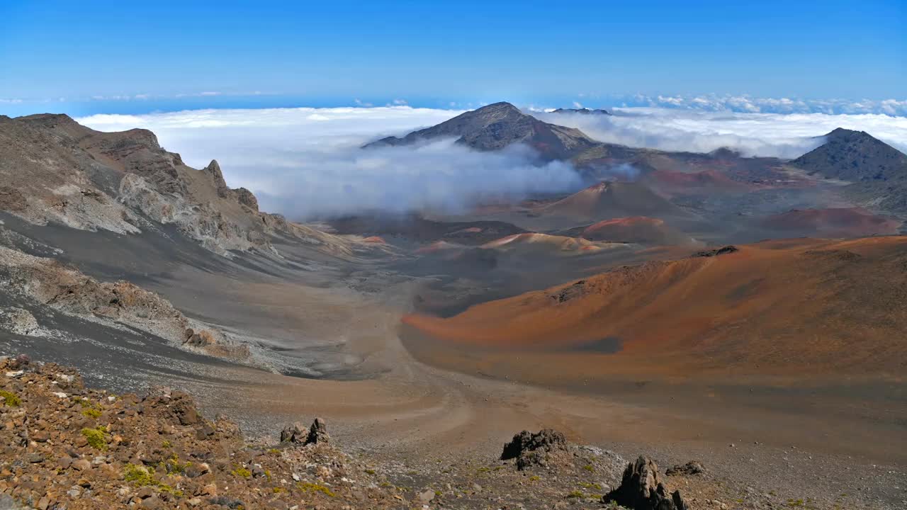 哈雷阿卡拉峰顶——哈雷阿卡拉峰顶五彩缤纷的火山口全景，被云海和蓝天包围。美国夏威夷毛伊岛。视频下载
