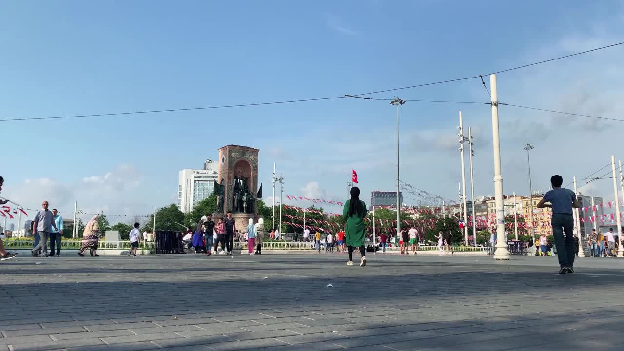 人们在伊斯坦布尔Beyoglu地区著名的旅游城市塔克西姆广场上行走的镜头。独立纪念碑就在眼前。视频素材