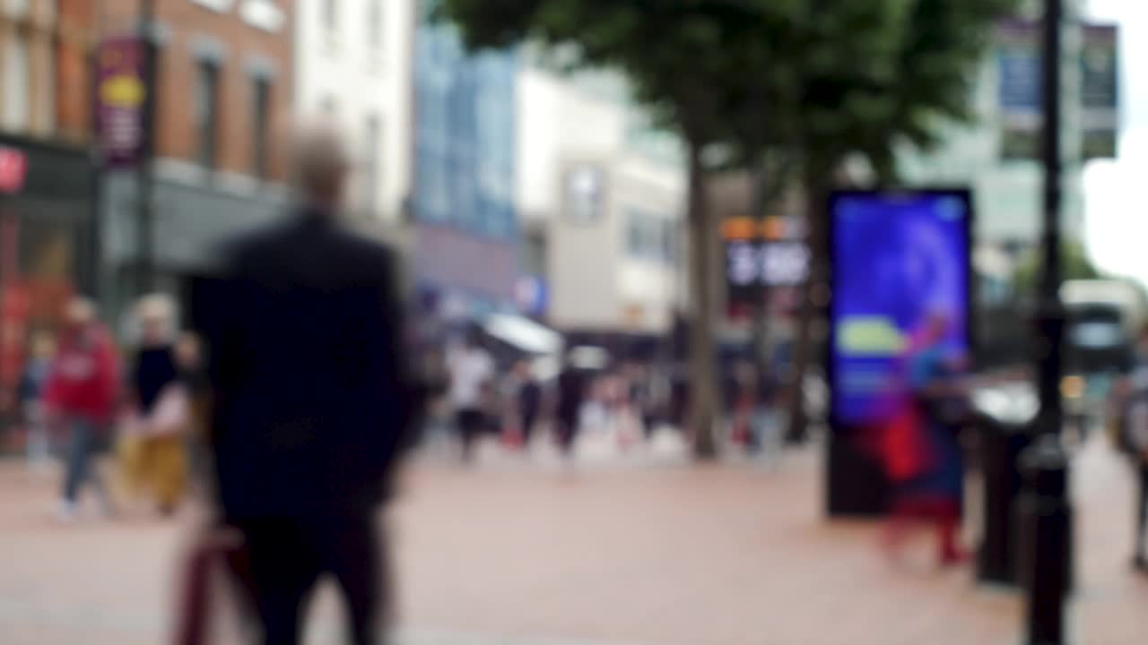4K时间流逝散焦匿名的人忙碌的购物者在购物的高街背景-模糊的通勤者在阳光明媚的一天。视频素材