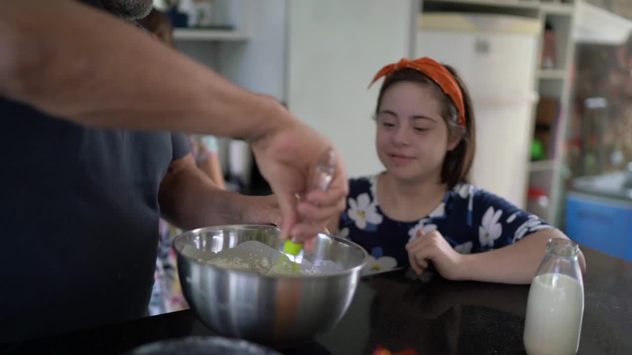 一家人一起做蛋糕，妈妈在家里拍摄——包括一个有特殊需要的女孩视频下载
