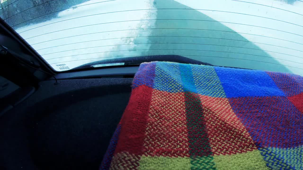 在乡村公路上旅行的汽车后备箱架子上的毯子视频下载