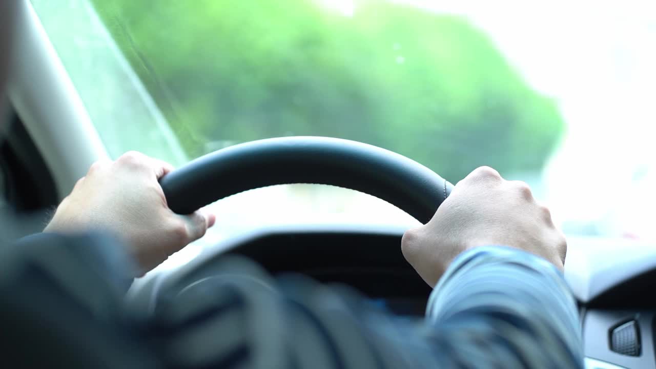 驾驶员坐在车后，双手紧紧握着方向盘，视频从车内传出视频素材