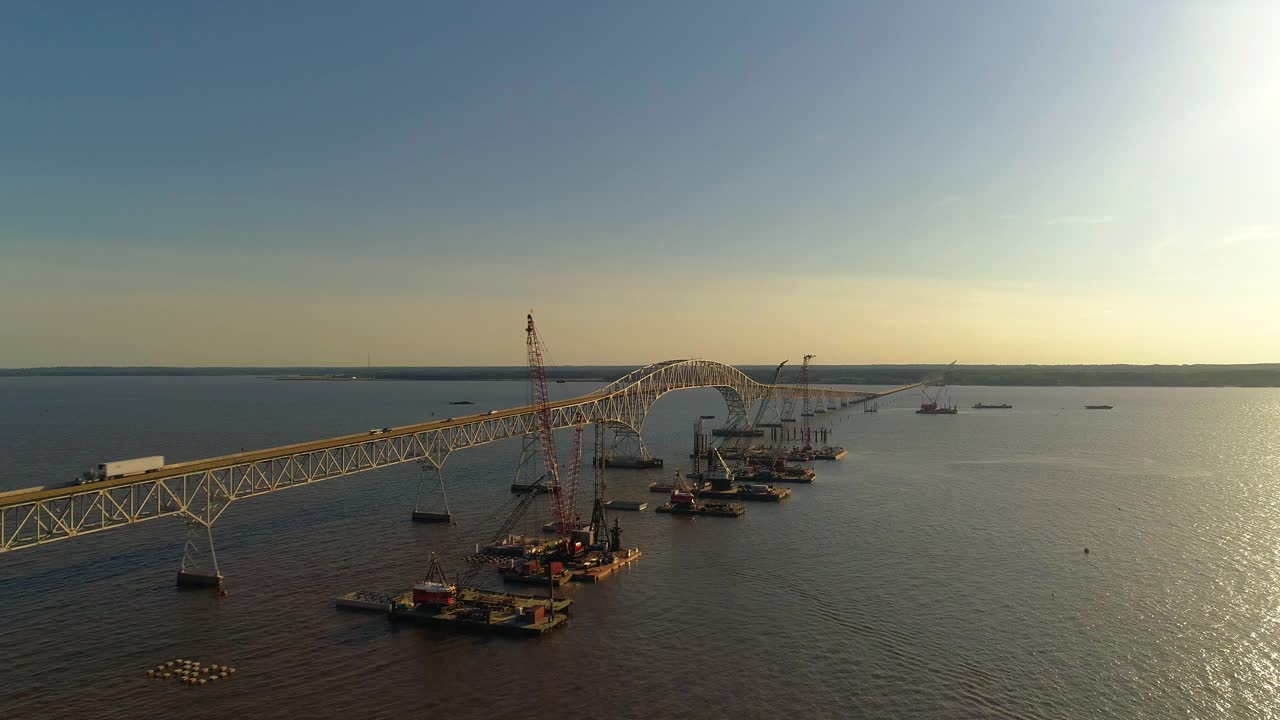 波托马克河重建鸟瞰图，靠近哈里·尼斯州长纪念馆/参议员托马斯·“麦克”·米德尔顿桥，连接弗吉尼亚州和马里兰州，水上有多艘浮吊船和建筑工地。视频下载