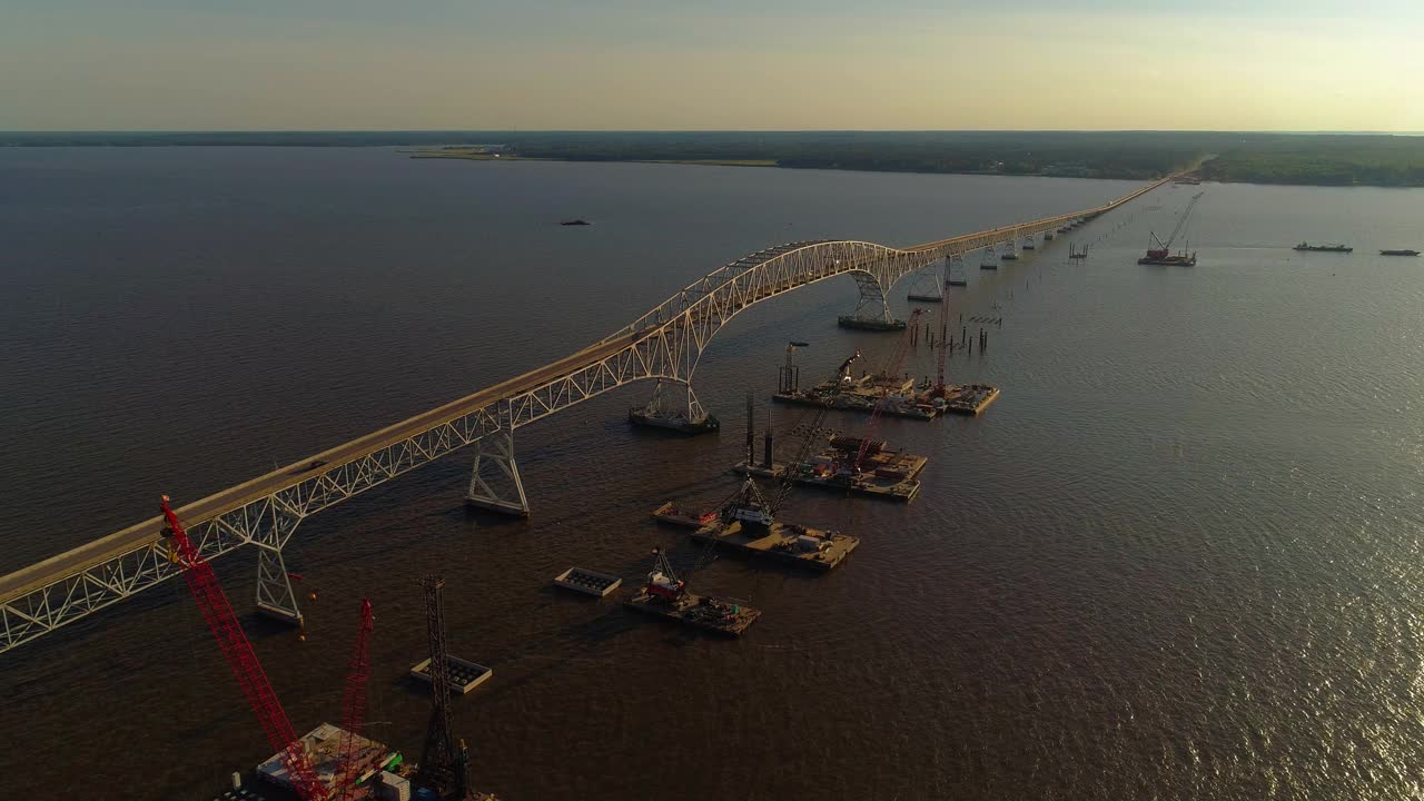 波托马克河重建鸟瞰图，靠近哈里·尼斯州长纪念馆/参议员托马斯·“麦克”·米德尔顿桥，连接弗吉尼亚州和马里兰州，水上有多艘浮吊船和建筑工地。视频素材