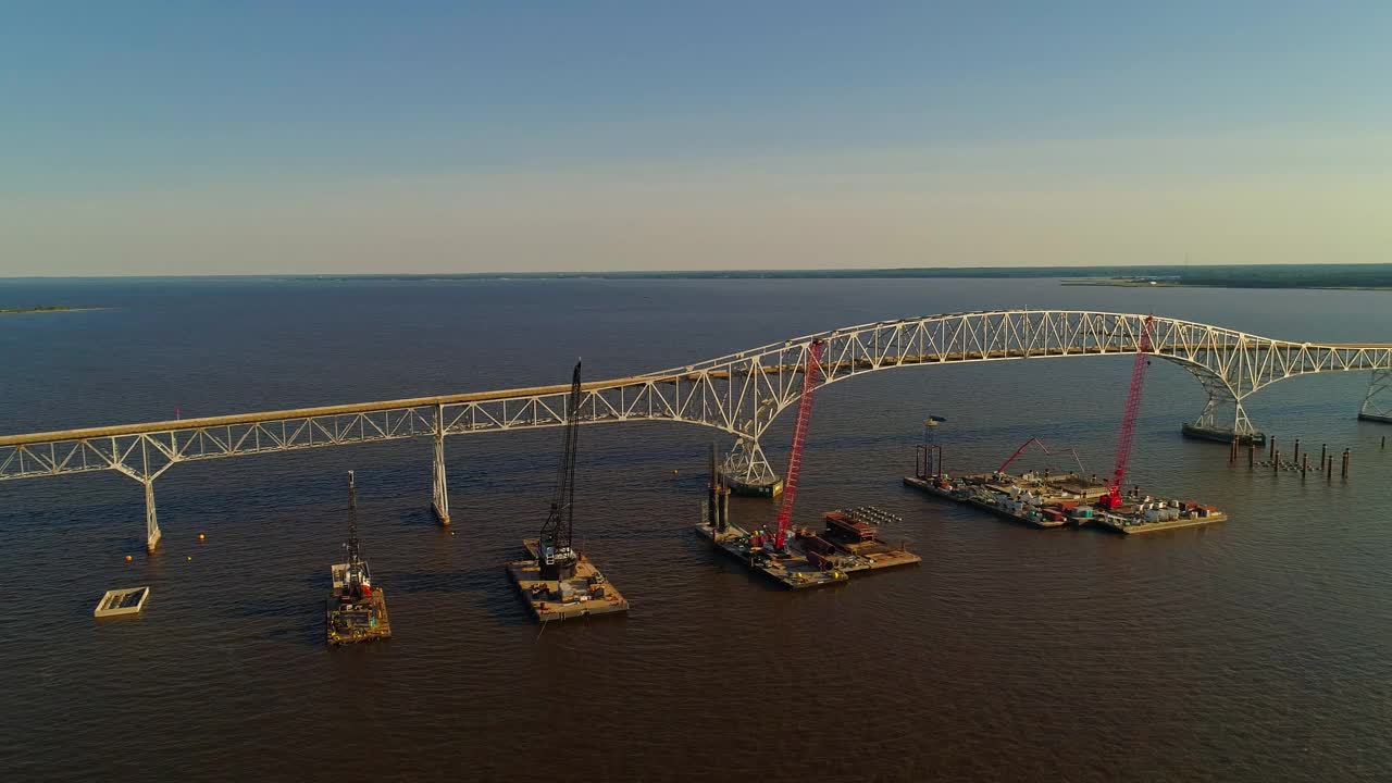 波托马克河重建鸟瞰图，靠近哈里·尼斯州长纪念馆/参议员托马斯·“麦克”·米德尔顿桥，连接弗吉尼亚州和马里兰州，水上有多艘浮吊船和建筑工地。视频下载