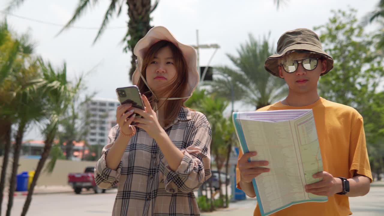 愉快的亚洲年轻夫妇游客拉着他们的手漫步在城市中。视频素材