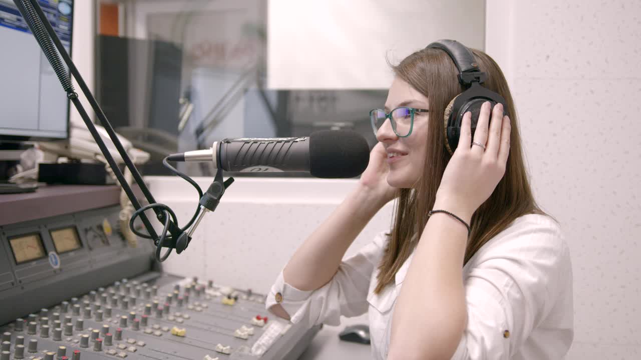 微笑的年轻女电台主持人在演播室播音视频下载