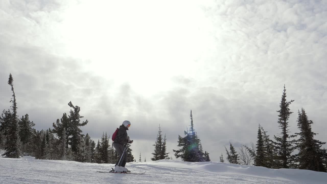 滑雪者在冬季阳光明媚的日子里在山间滑雪道上滑雪视频素材