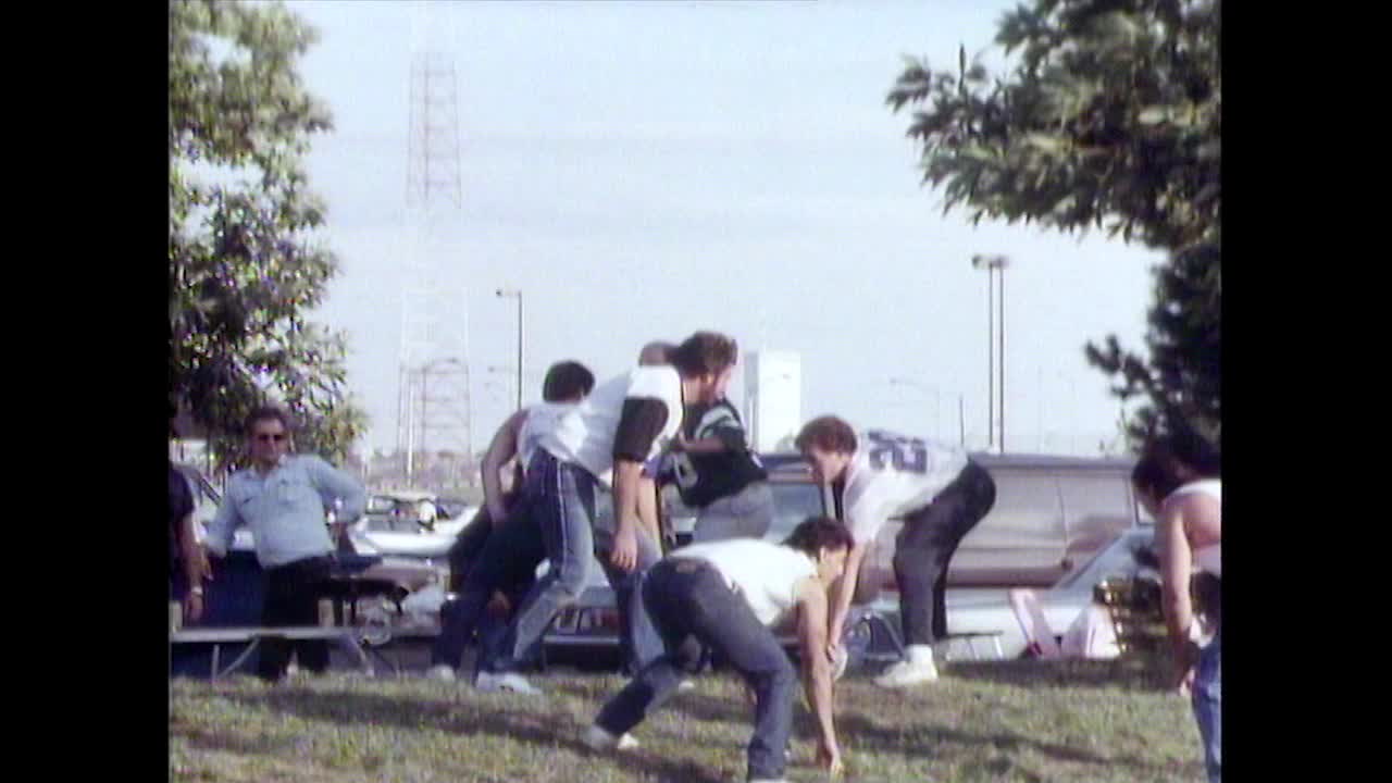 体育迷们在Meadowlands的停车场里踢足球;1987视频素材