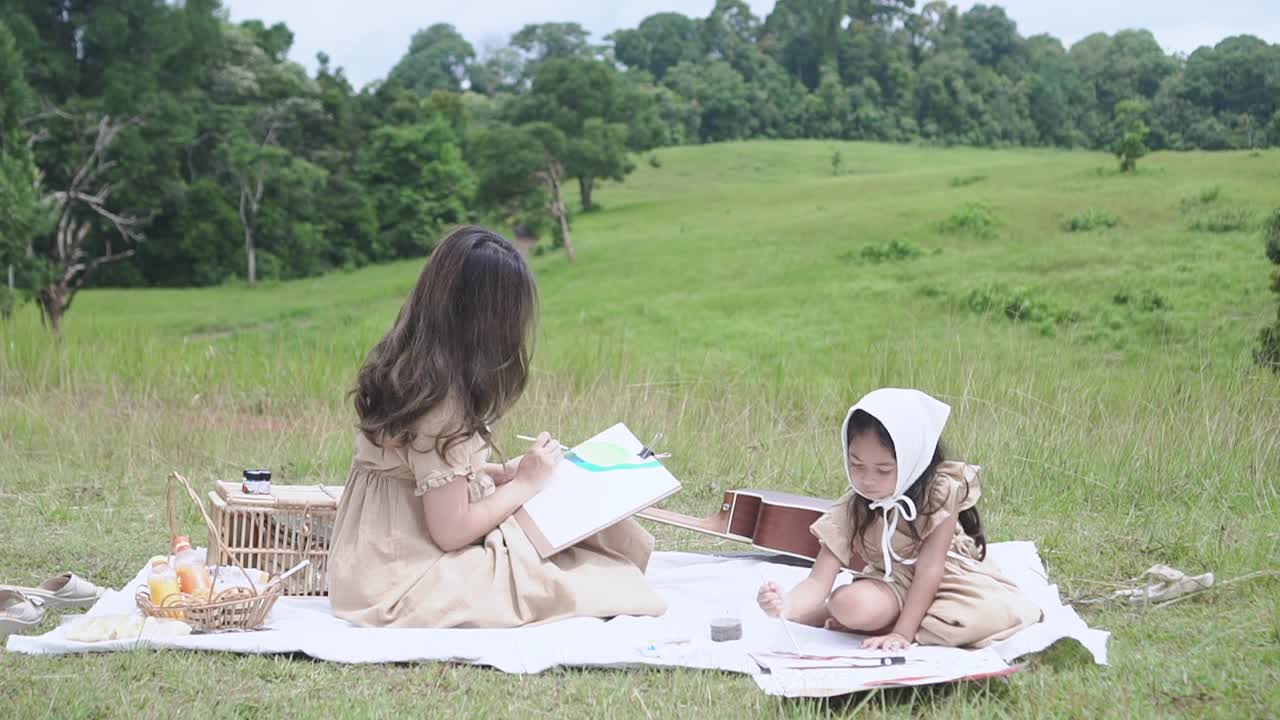 美丽的年轻母亲和她的小女儿在野餐的乐趣。视频下载