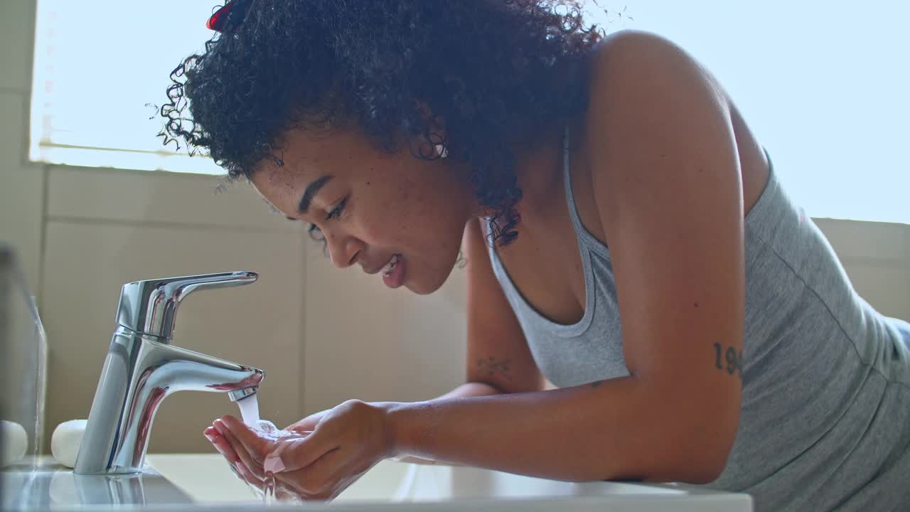 一名女子在浴室里洗脸的4k视频视频素材
