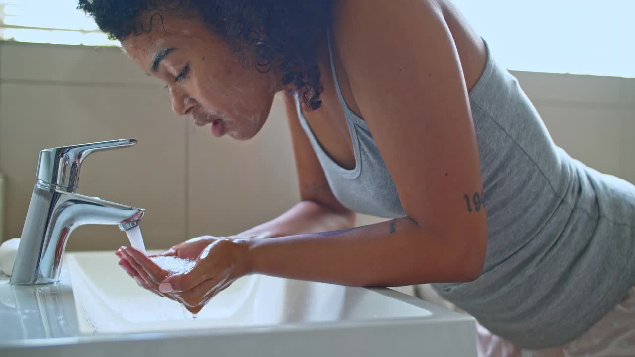 一名女子在浴室里洗脸的4k视频视频素材