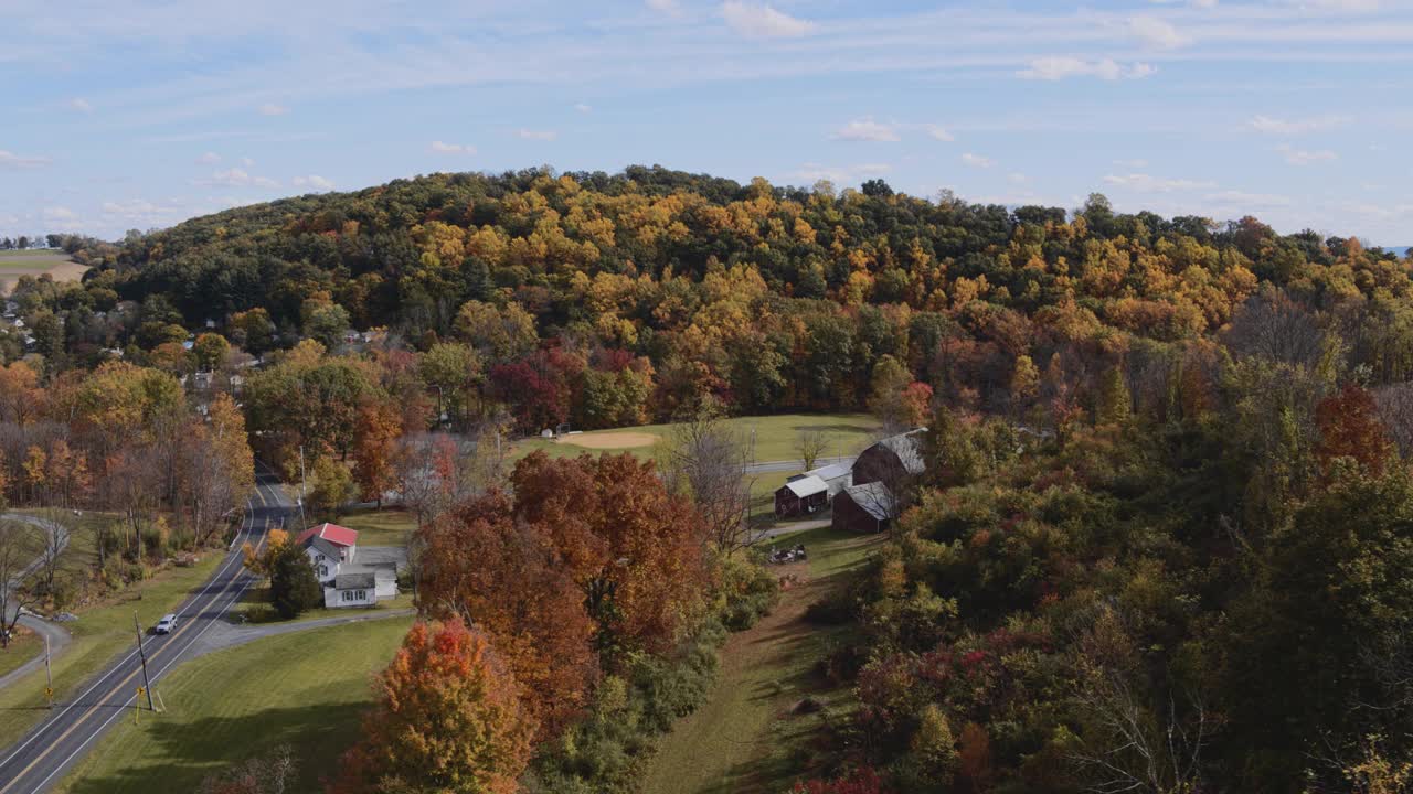 五彩缤纷的秋天在宾夕法尼亚州农村。从空中俯瞰里海镇附近的小村庄，群山之间被树林覆盖。航拍视频与平移摄像机运动。视频下载
