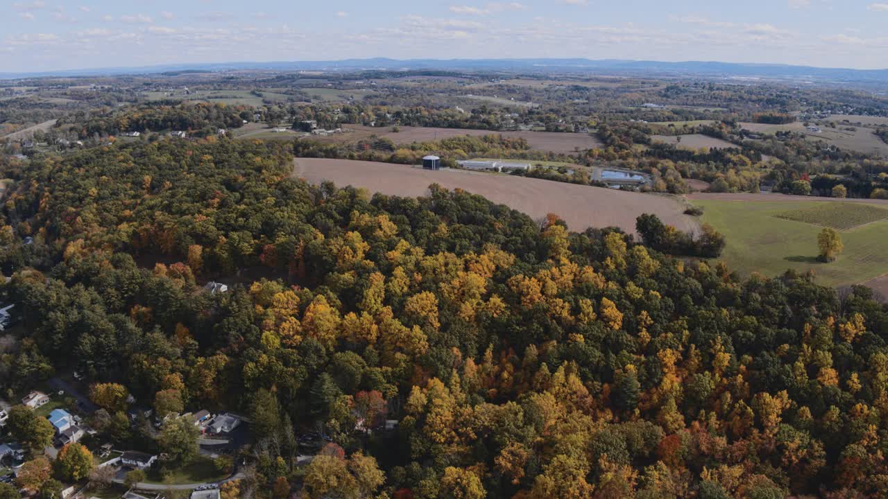 五彩缤纷的秋天在宾夕法尼亚州农村。航拍里海镇附近的农田，山与山之间的森林、拼凑的田野、村庄和农场。空中视频与下降的摄像机运动。视频素材
