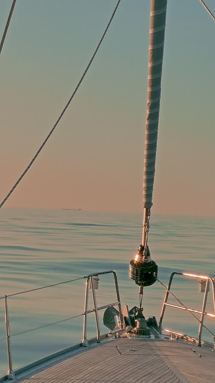 日落时分，帆船在加勒比海平静的海面上低头。帆和钻机的视图视频下载