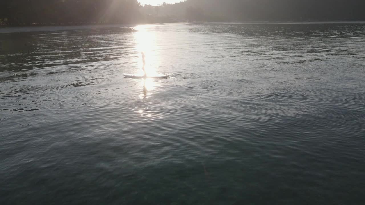 在阳光明媚的夏日里，一对夫妇在海上玩桨板。视频下载