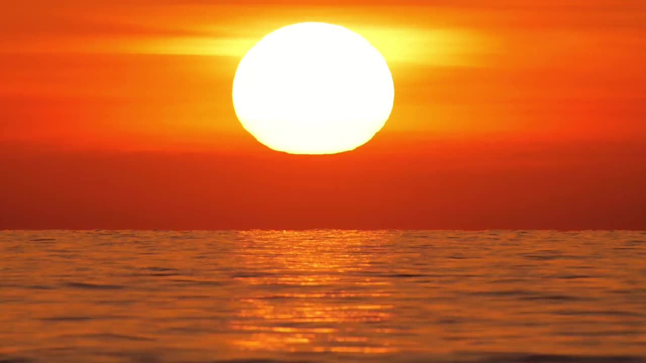 大红热太阳在温暖的空气扭曲上方的海洋地平线，日落在海上，大升起的太阳与云。特写镜头长焦镜头。旅行，开始，自然的概念视频素材