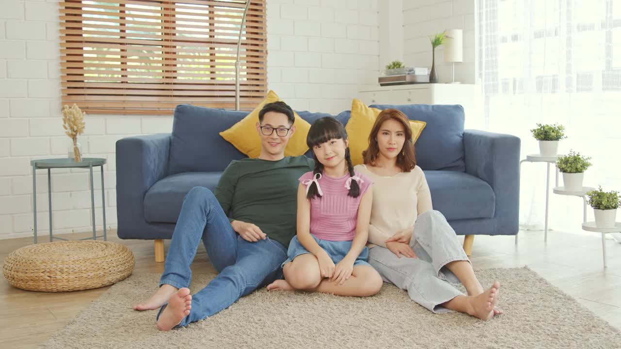 幸福亚洲家庭一起在家中客厅的沙发上摆出迷你心。视频下载