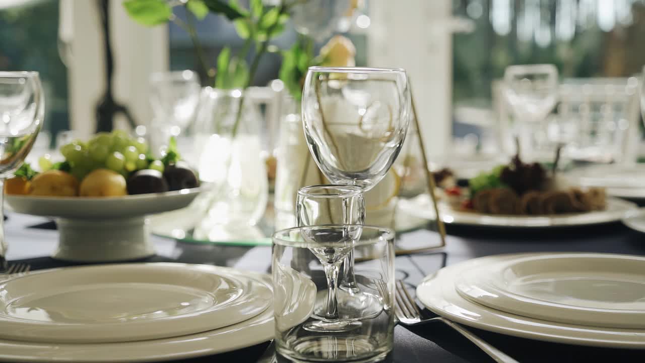 玻璃杯和盘子放在一张美丽的节日餐桌上。盘子洗干净了，正在等客人视频素材