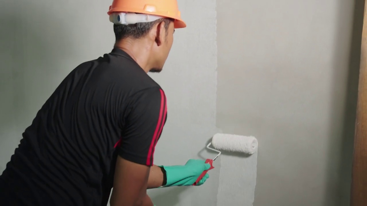 亚洲男人在家里刷墙。视频素材