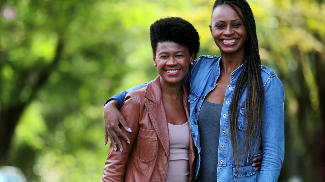 两个非洲朋友对着镜头微笑。黑人妇女在一起视频下载