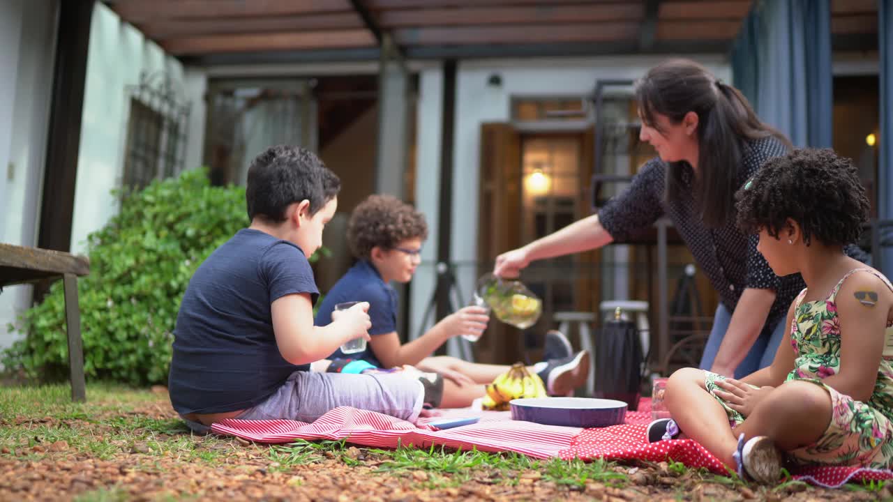 孩子们在户外野餐时，母亲给他们倒果汁视频下载