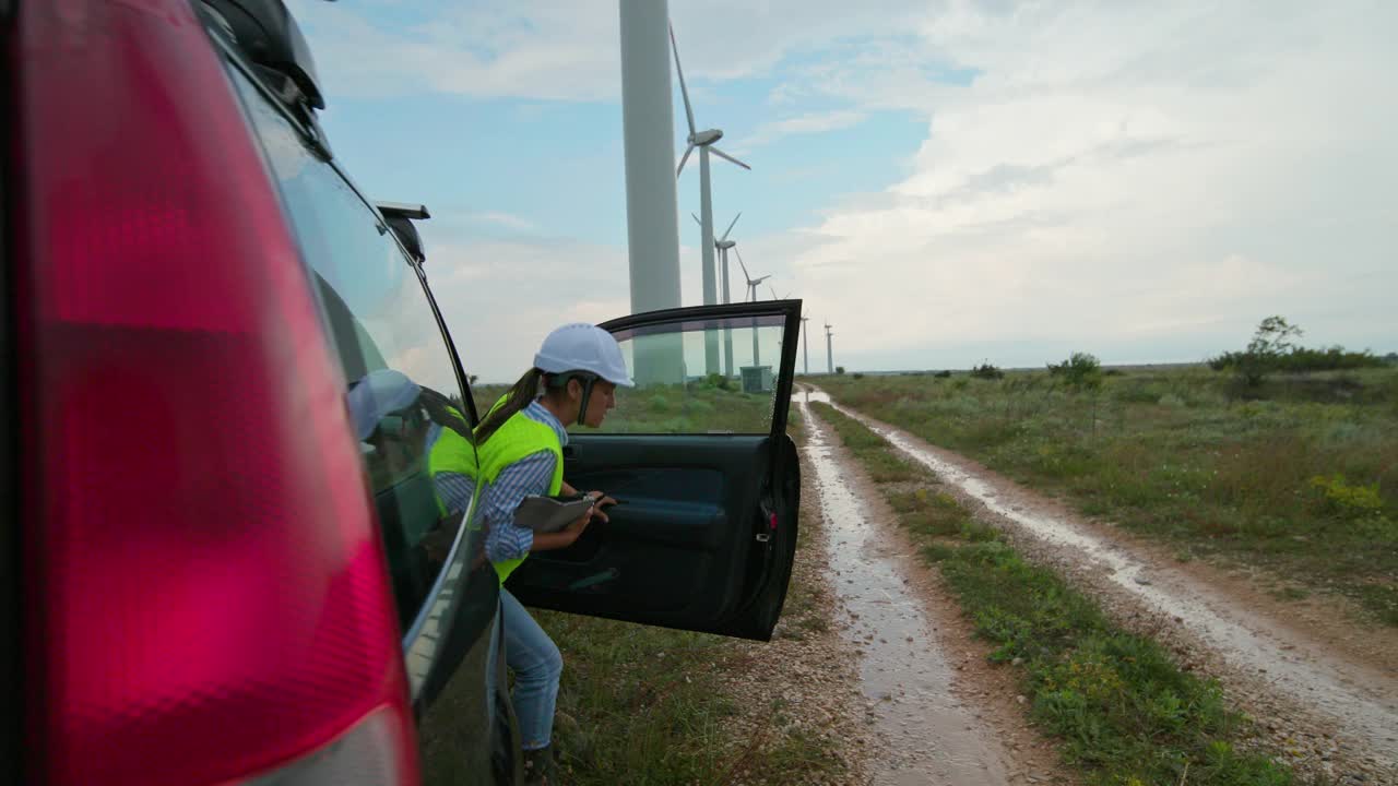 风力涡轮机农场的工程师在一个雨天下车。可再生能源系统。视频素材